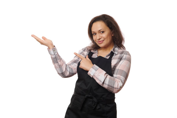 愉快的女服务员，在围裙的酒吧女服务员，微笑着在相机上，指着复印空间，她在她的手手掌向上图片下载