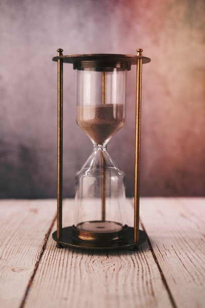 沙漏在桌子上，沙子流过沙漏的球图片下载