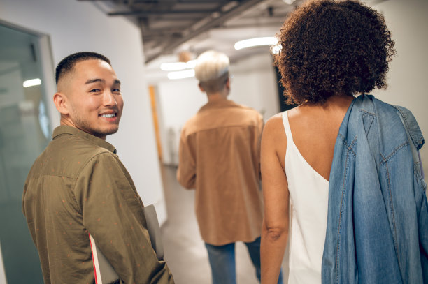 兴高采烈的公司员工在走廊上对着镜头摆姿势图片下载