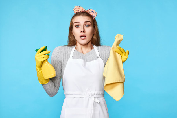女人戴手套和清洁围裙，清洁抹布和清洁剂喷雾器图片下载