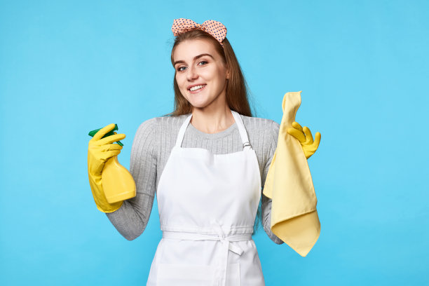 女人戴手套和清洁围裙，清洁抹布和清洁剂喷雾器图片下载