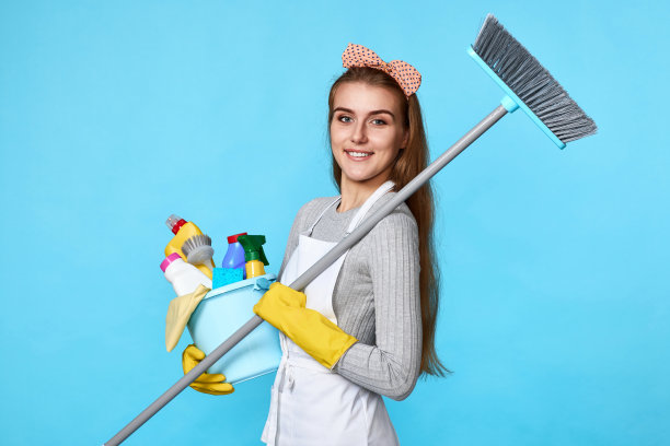 戴手套的女人拿着一桶清洁剂和扫帚图片下载