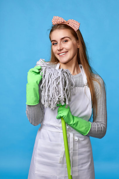 女人在橡胶手套和清洁围裙拿拖把图片下载