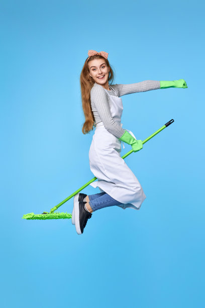 女人戴着橡胶手套和清洁围裙用拖把洗地板图片下载