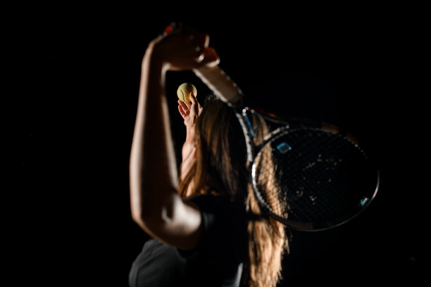 选择性地把注意力集中在女子手中的网球上，女子挥舞球拍击球图片下载