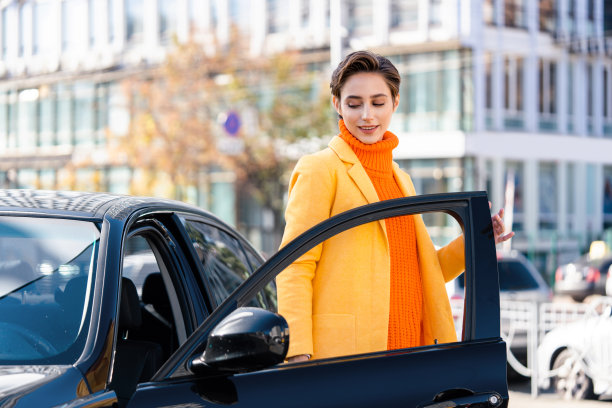 年轻漂亮的短发女子在城市里开车图片下载