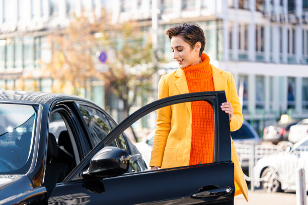 年轻漂亮的短发女子在城市里开车图片下载