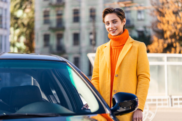 年轻漂亮的短发女子在城市里开车图片下载