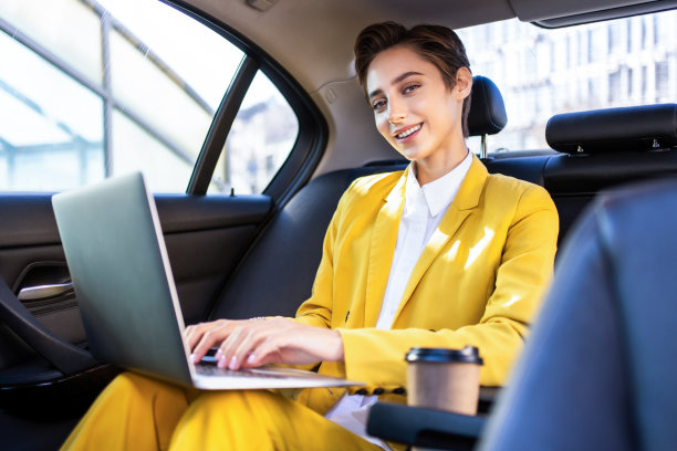 年轻漂亮的短发女子在城市里开车图片下载