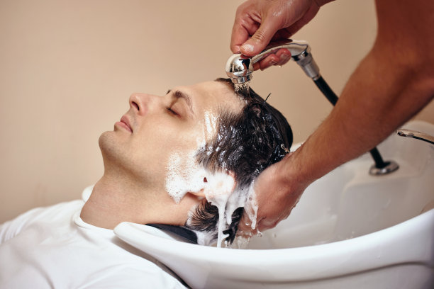 理发师正在给白人男子洗头，特写图片下载