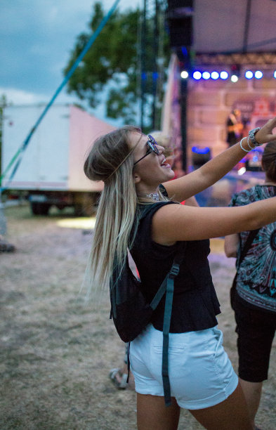 在人群和霓虹灯的背景下，女孩站在音乐会上图片下载