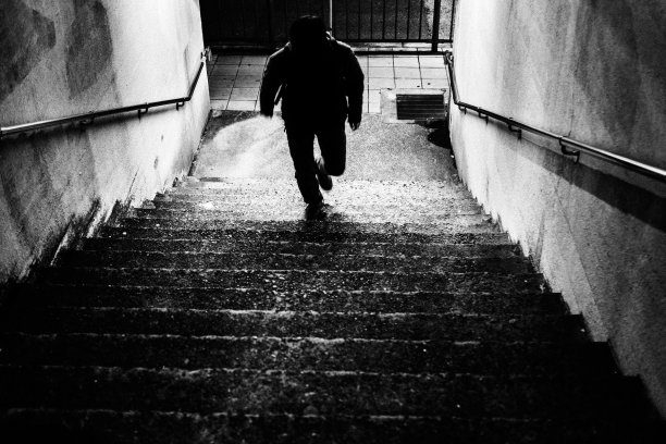 一个人的剪影从地下通道跑上楼梯到地面图片下载