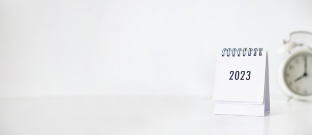 新年2023商务日历和闹钟在新年当天的办公桌上。制定一个年初的工作计划。关于庆祝，商业，圣诞节，新年的概念。图片下载