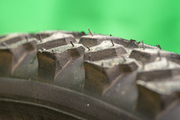 黑色自行车轮胎特写，表面有毛皮，绿色背景图片下载