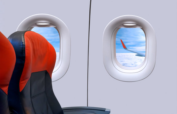 当飞机飞过白云蓝天时，机舱内的窗户和乘客座位图片下载
