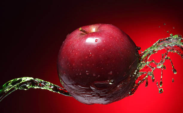 鲜红的苹果在红色的背景上溅起水花图片下载