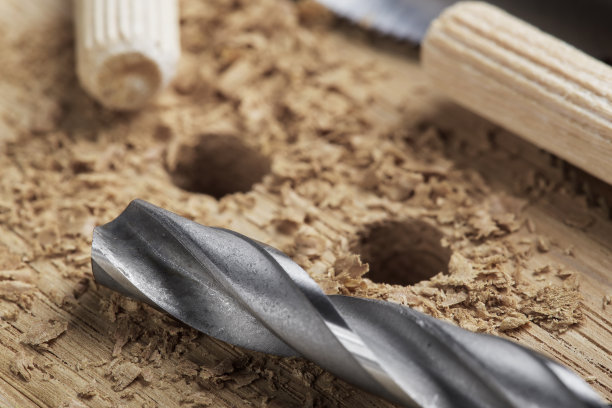 钻头在橡木木板上钻孔，用于木销子。图片下载