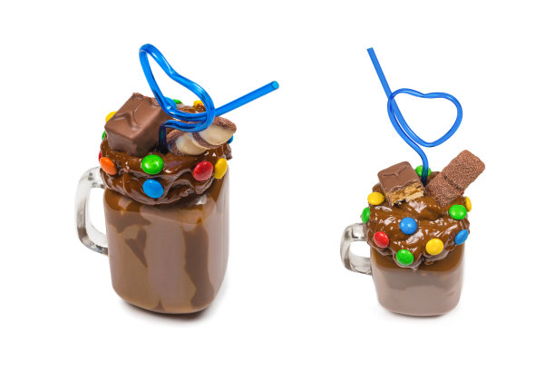 巧克力奶昔加鲜奶油，饼干，华夫饼，装在玻璃罐中。"怪胎还是疯子"的甜奶昔。孤立。图片下载