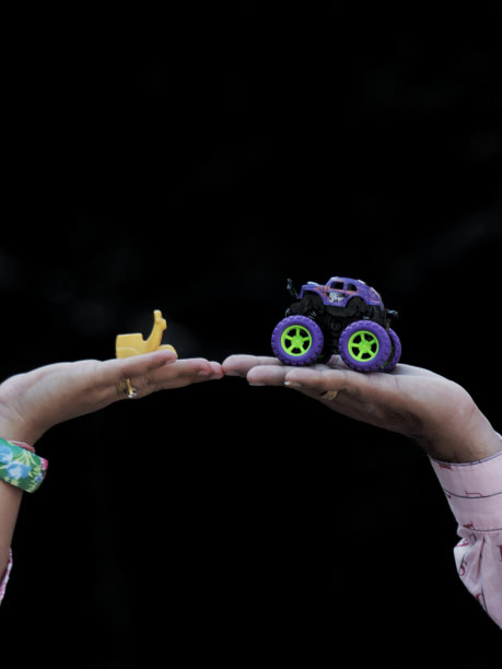 玩具Vespa和怪物卡车在人类手中的股票照片图片下载
