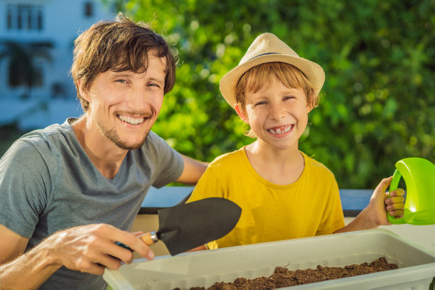 爸爸和儿子正在阳台上做园艺。儿童的自然发展图片下载