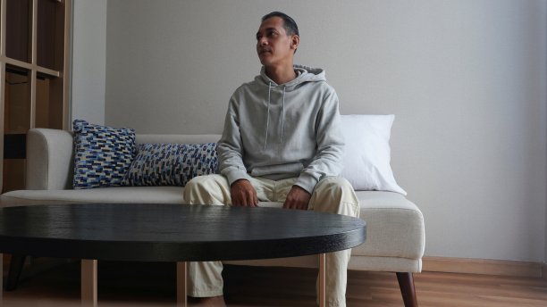 一个男人坐在客厅的沙发上享受这一天图片下载