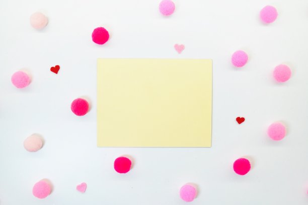 在白色背景上的黄牌评论空间的模型，背景中有红色和粉红色的毛球和心形图片下载