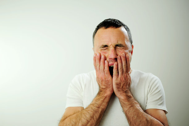 累了想睡觉厌倦了怀旧悲伤的男人打呵欠，他紧紧地闭上眼睛，张开嘴巴毛茸茸的手趴在他的脸颊上，他有黑色的头发和灰色的情绪的男人图片下载