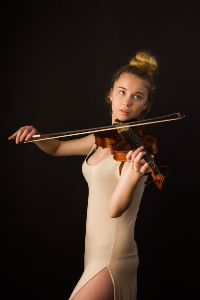 垂直肖像的白人金发女子在芭蕾舞演员服装演奏小提琴图片下载