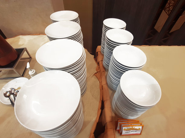 宴会桌上一堆整齐的白色盘子和碗图片下载