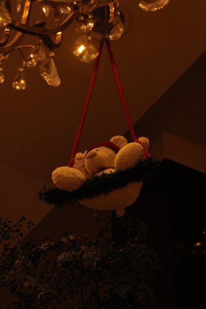 挂在花环上的泰迪熊装饰品。前景中的吊灯图片下载