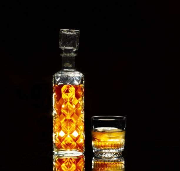 一个老式威士忌酒瓶和一个玻璃杯的静物图片下载