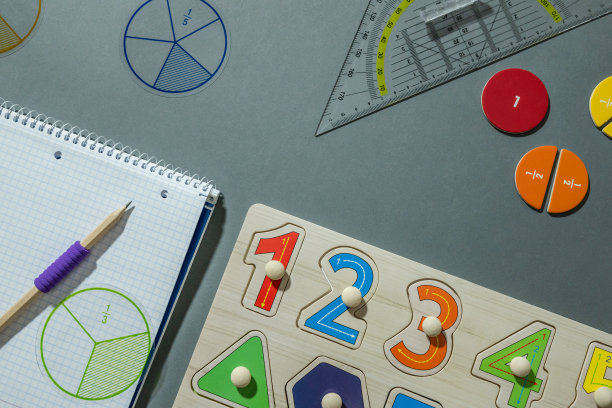 一套数学和学习用品。分数，尺子，铅笔，灰色背景的记事本。回到学校，趣味教育理念图片下载