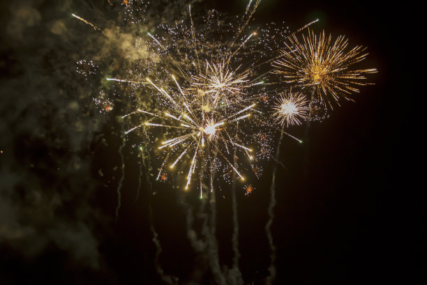 烟花爆炸从美丽的星星，飞溅，火花和明亮的线与烟从红色和黄色颜色的黑色天空图片下载