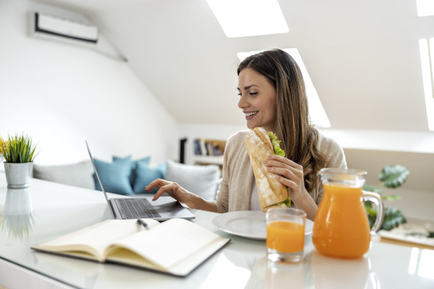 厨房里的女人在用笔记本电脑工作图片下载
