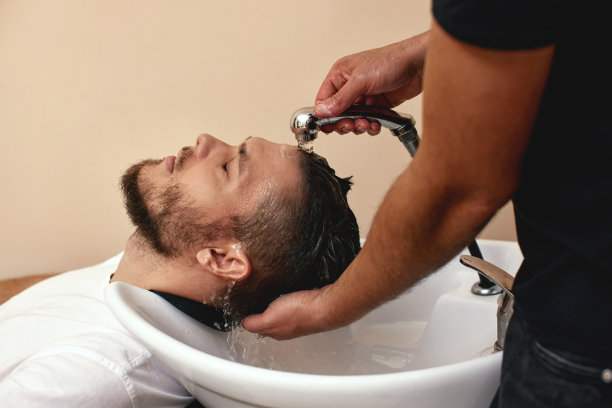 理发师正在给白人男子洗头，特写图片下载