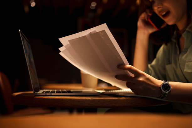 年轻的女商人在工作和在咖啡馆打电话时持有文件。图片下载