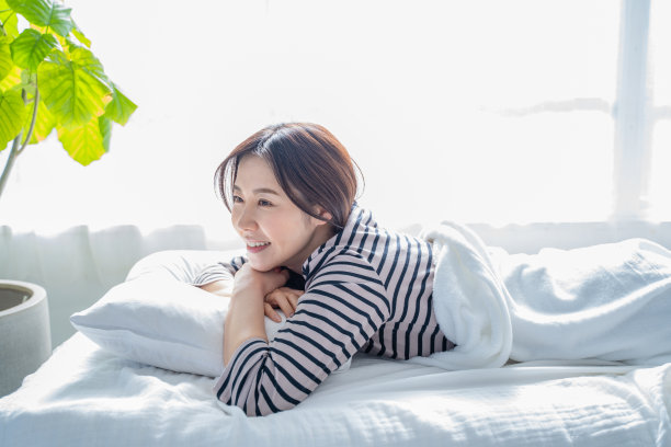 微笑着醒来的女人在床上睡得很好。图片下载