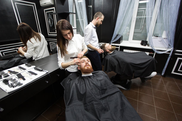 在理发店工作。两位大师在工作。图片下载