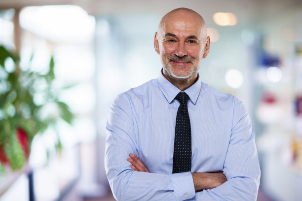 一个中年商人站在办公室里图片下载