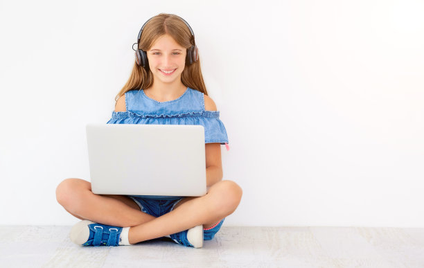 坐着的女孩带着笔记本电脑和耳机图片下载