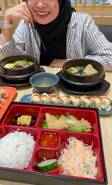 年轻的戴头巾的女人吃日本食物图片下载