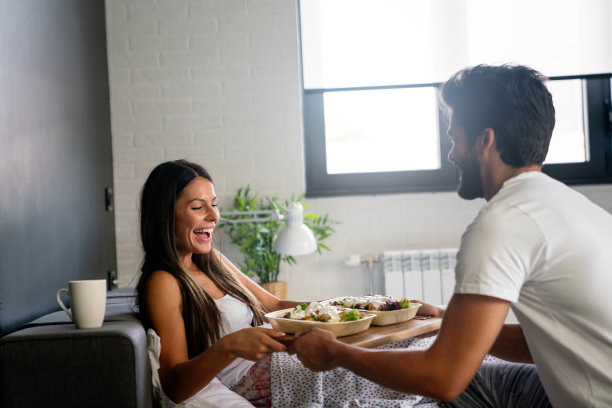 快乐的男人把早餐送到他女朋友的床上图片下载