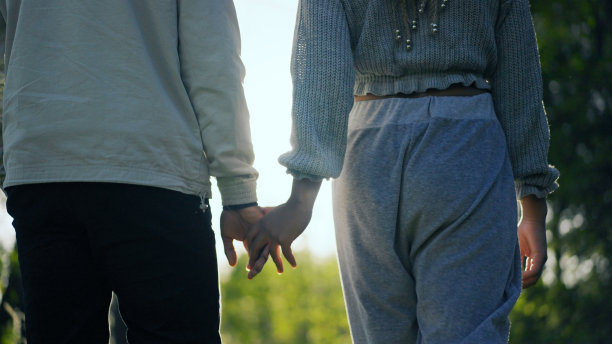 可爱的非洲情侣在公园里散步。手牵着手图片下载