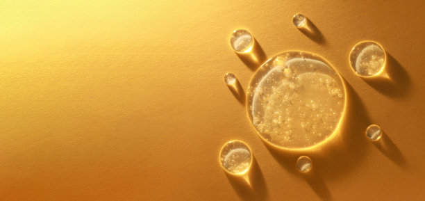 圆形透明滴透明凝胶血清在金色背景图片下载