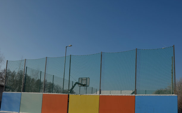 公园操场上的攀岩墙。实心梁与攀爬手柄的形式彩色石头制成的复合材料抱石，悬垂，桥梁，隧道，蓝天图片下载