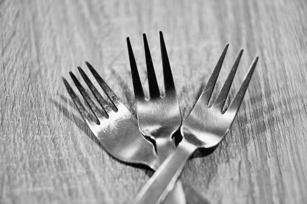 木桌上三个银叉的特写灰度镜头图片下载