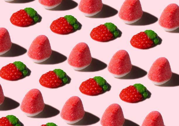 粉红色背景上五颜六色的软糖图案。图片下载