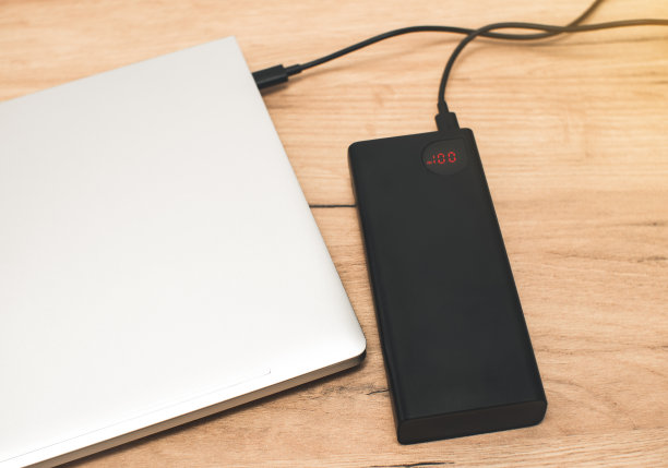 带有usb-c电缆的充电宝正在为笔记本电脑充电。现代信息技术。图片下载