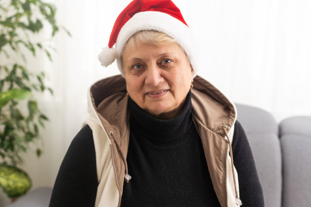 祖母或老妇人戴着圣诞老人的帽子;完美的圣诞礼物图片下载