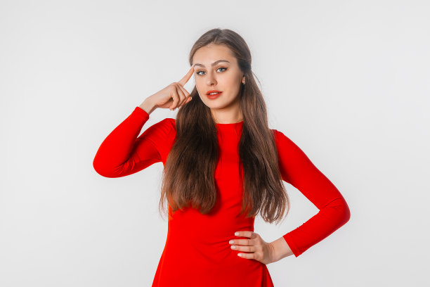 年轻女士有个好主意。年轻女孩的长发肖像，指着太阳穴，站在白色的工作室背景图片下载